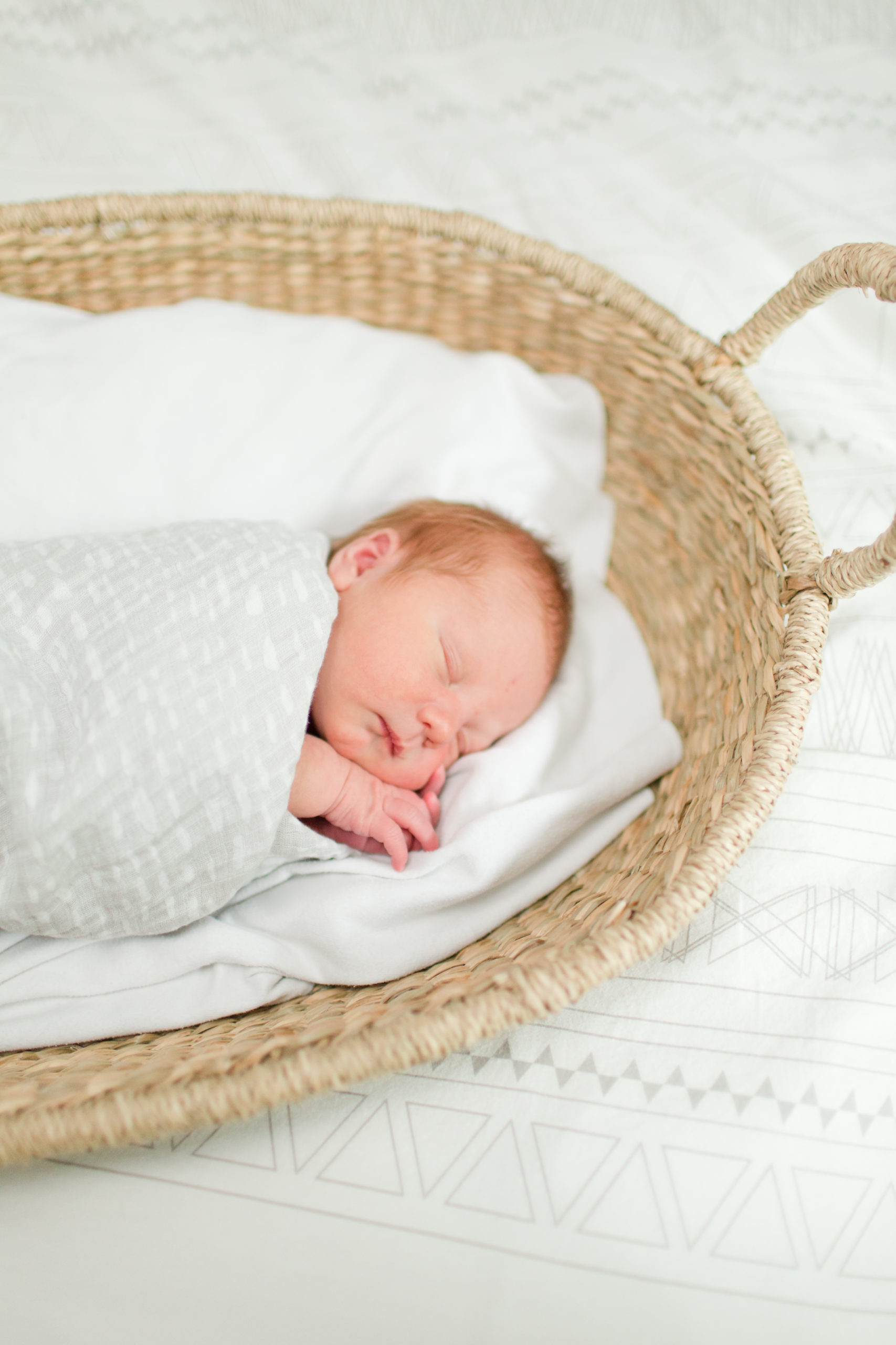 Boston Newborn Photographer - Newborn baby wrapped in swaddle sleeping in moses basket