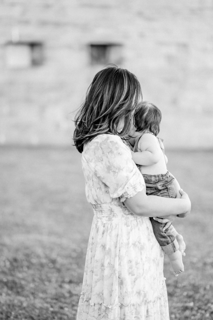 Boston mama holding her baby during photo session at Castle Island with Corinne Isabelle Photography
