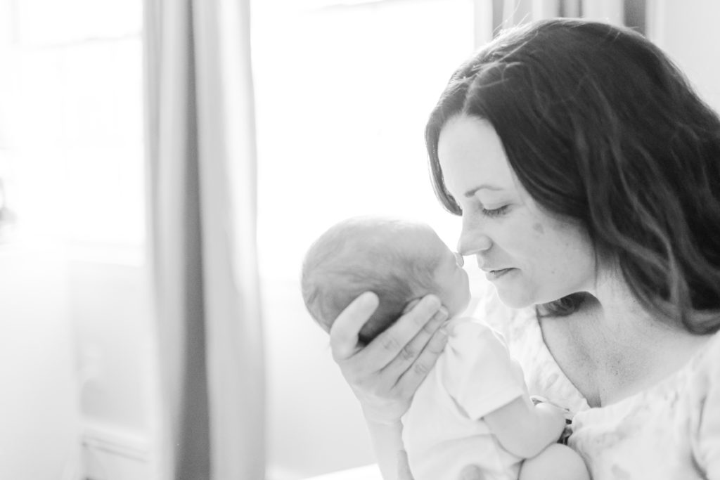 Newborn baby being held by their mother / Boston Area Newborn Photographer Corinne Isabelle