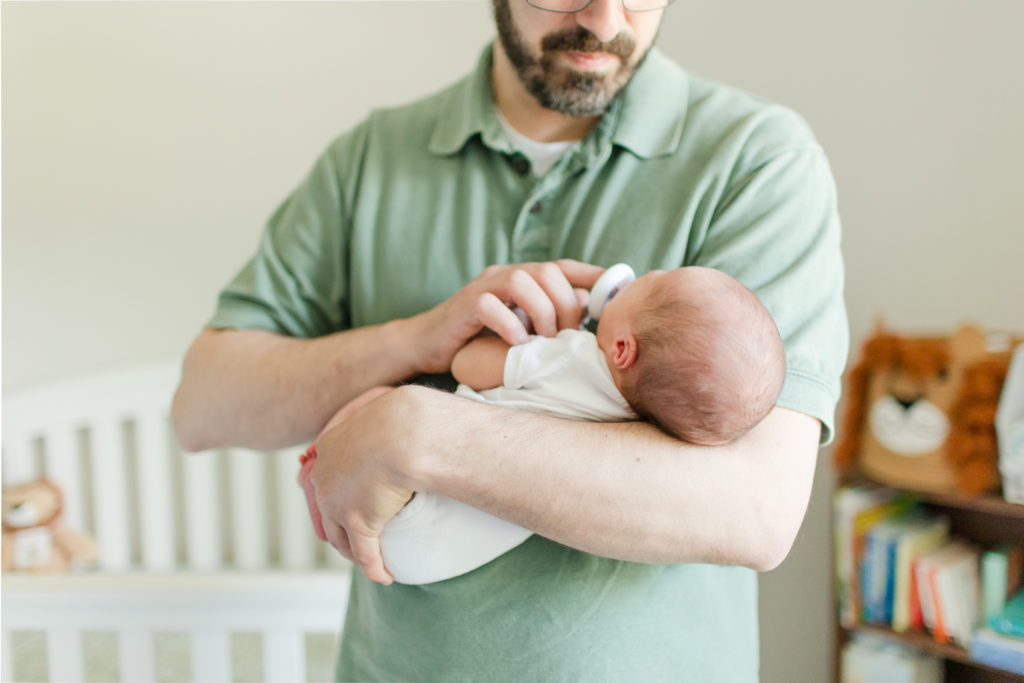 Newborn baby being held by their father / Boston Area Newborn Photographer Corinne Isabelle