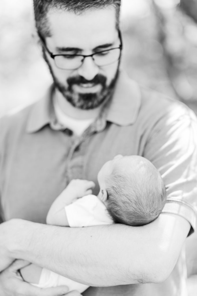 Close up photo of newborn baby being held by their father outdoors / Boston Area Newborn Photographer Corinne Isabelle