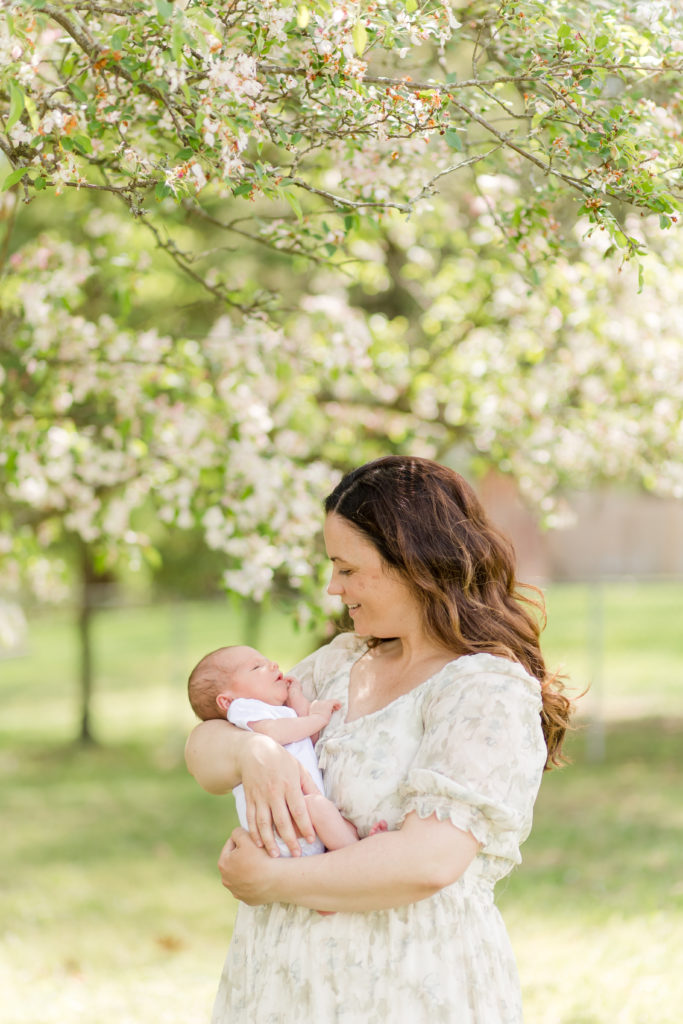Newborn baby being held by their mother during photo session with Holliston Newborn Photographer Corinne Isabelle