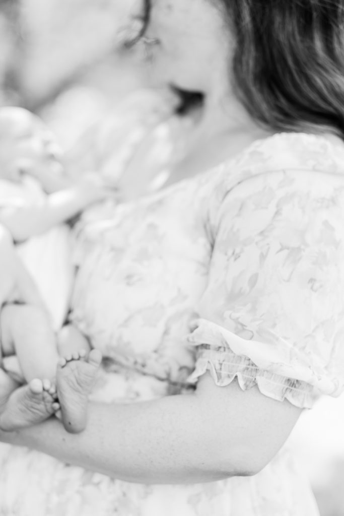 Close up photo of newborn baby being held by their mother outdoors / Boston Area Newborn Photographer Corinne Isabelle
