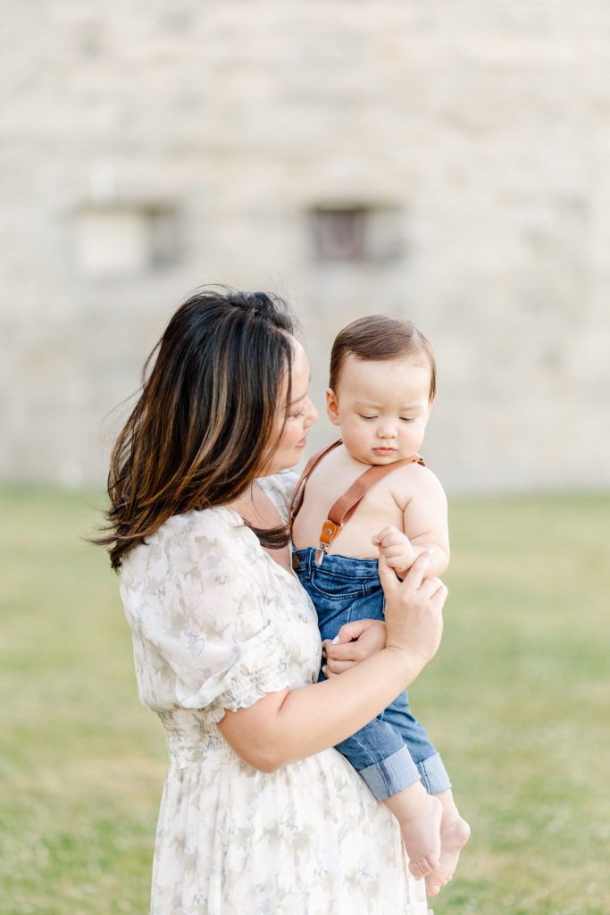 Mom holding her baby boy outdoors at Castle Island in South Boston during photo session with Boston baby photographer Corinne Isabelle