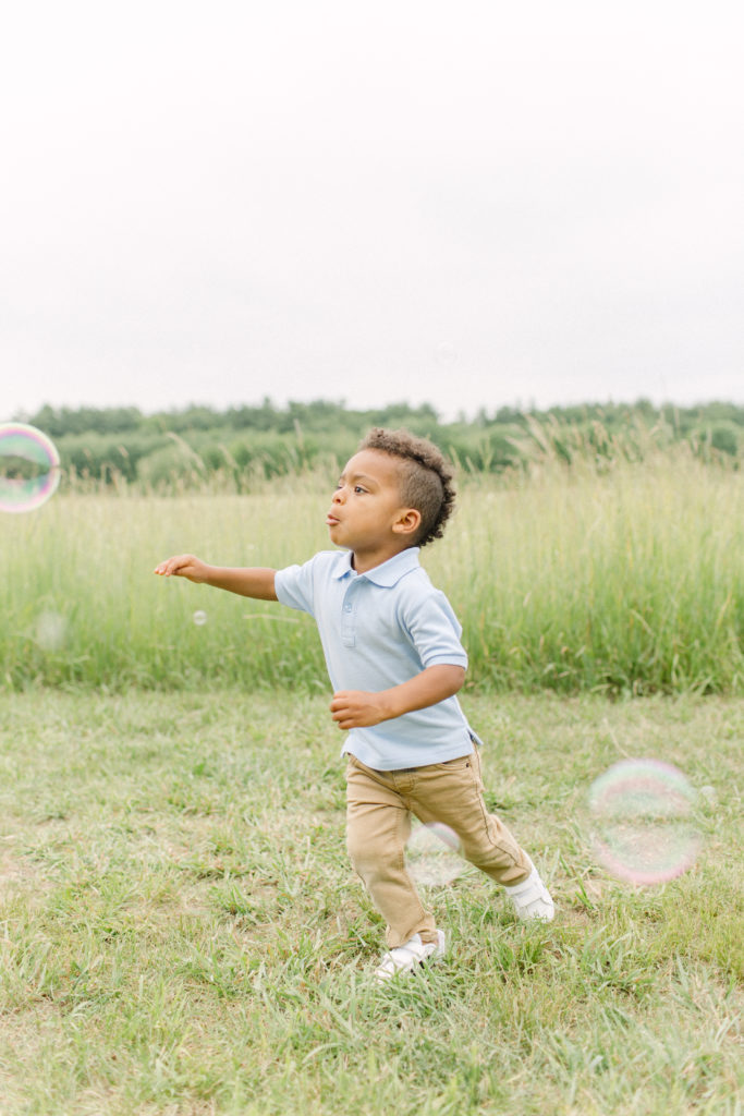 Young boy running around outdoors during a lifestyle family session with Boston Family Photographer Corinne Isabelle