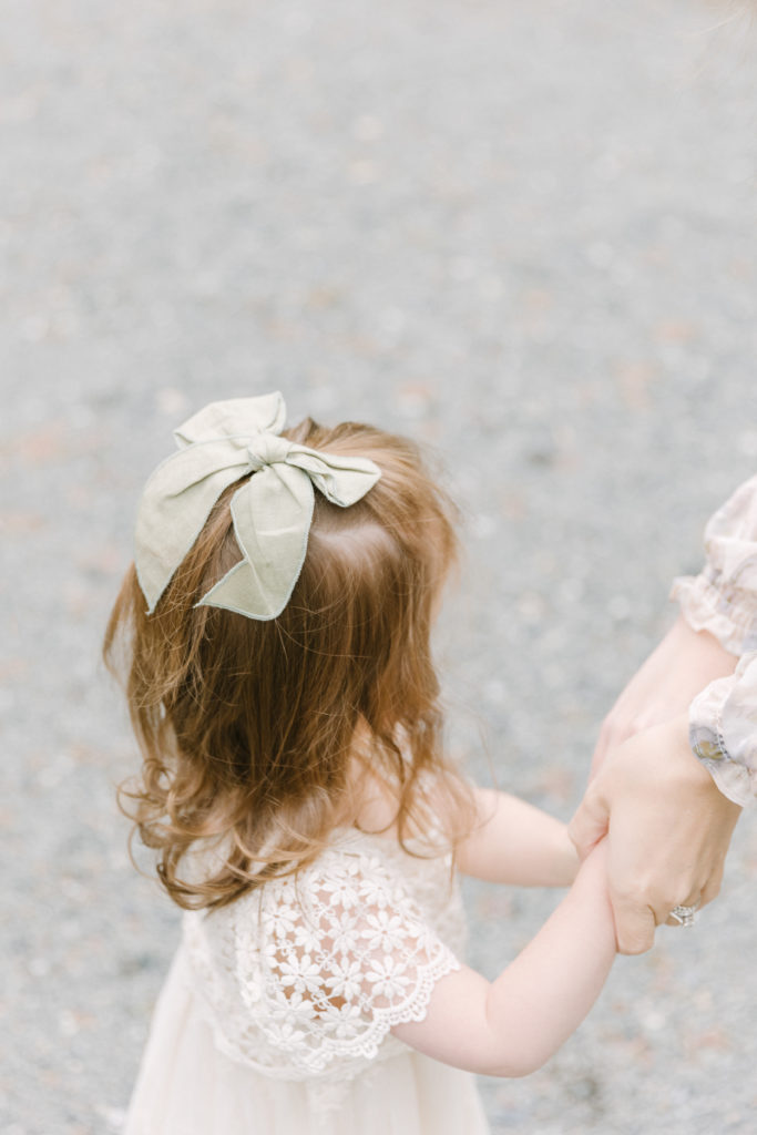 Young girl holding her mom's hand during Boston family photography session with  Corinne Isabelle