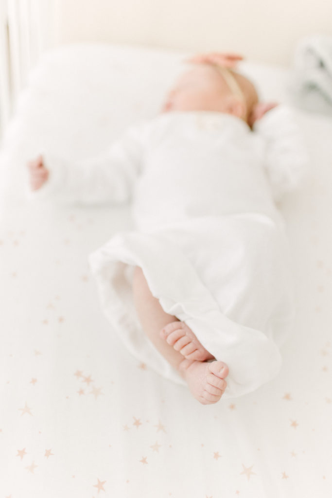 Newborn baby laying in crib during photo session with Boston Newborn Photographer Corinne Isabelle
