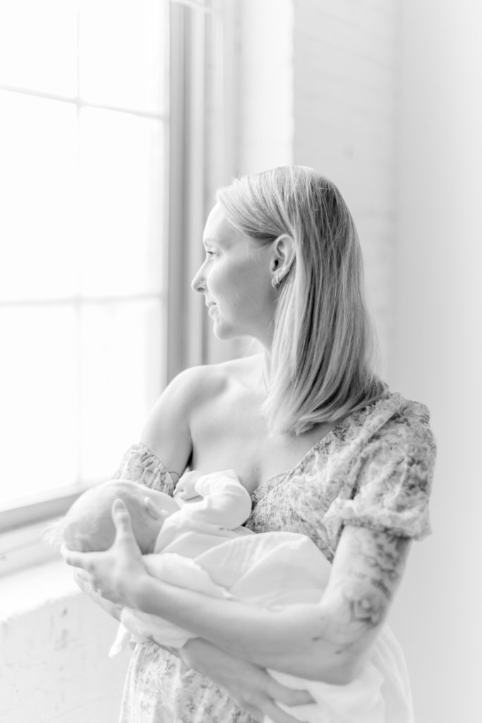 Young Boston mom breastfeeding her newborn baby boy during Boston photo shoot with Motherhood photographer Corinne Isabelle