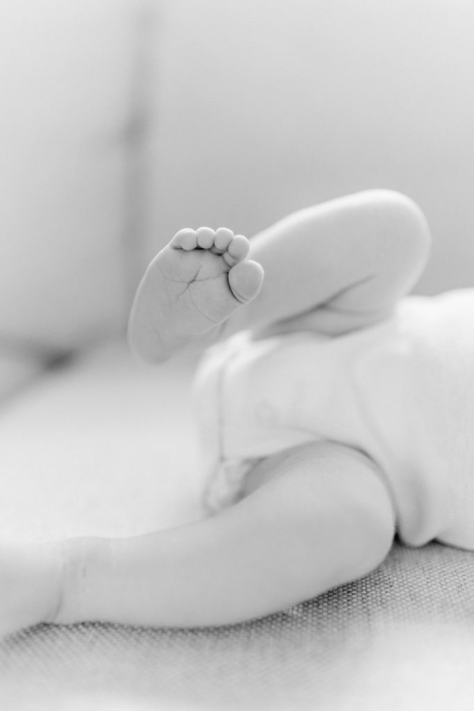 Black and white photo of a close up of newborn baby toes during photo session with Natick newborn photographer Corinne Isabelle