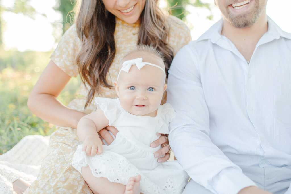 Young couple sitting and holding their baby girl.